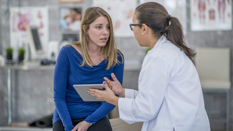 年轻女子与医生讨论肾脏疾病诊断。