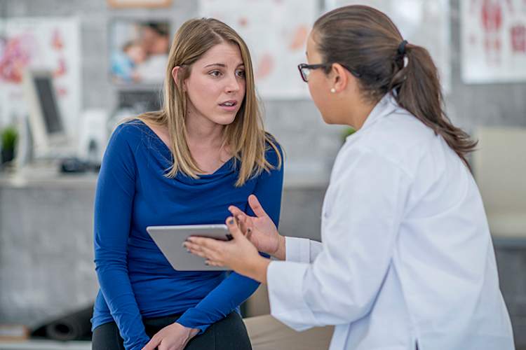 年轻女子与医生讨论肾脏疾病诊断。