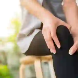 Young woman holding knee in pain