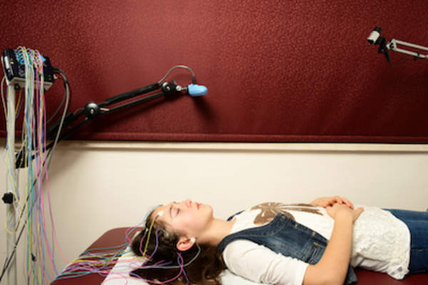 女子正在接受脑电图,同时睡眠研究大脑活动。