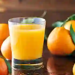 Glass of fresh orange juice and oranges.
