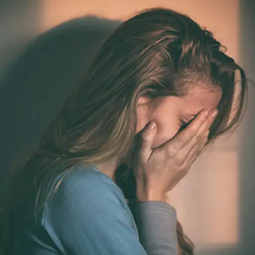 有头的沮丧的妇女在她的手上。