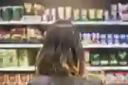 A woman looks at food options at a grocery store