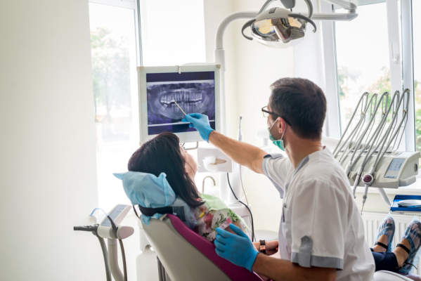 牙医在X光片上显示病人的牙齿