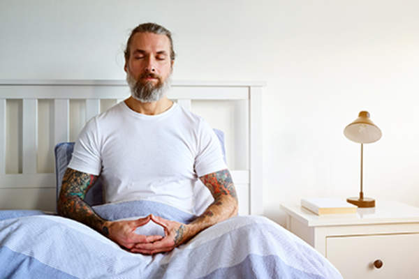 在床上冥想的人。