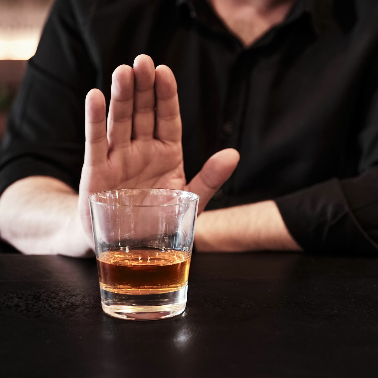 一个人举起他的手拒绝喝酒