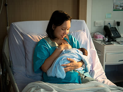母亲哺乳的新生婴儿在医院里。