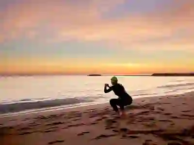 一名女子在游泳前在海滩上伸展身体
