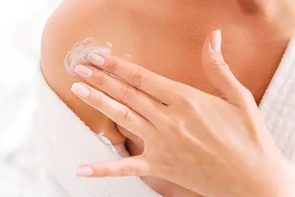 女人在皮肤上涂乳液。