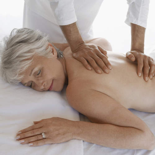 一位上了年纪的妇女因背痛而接受按摩。