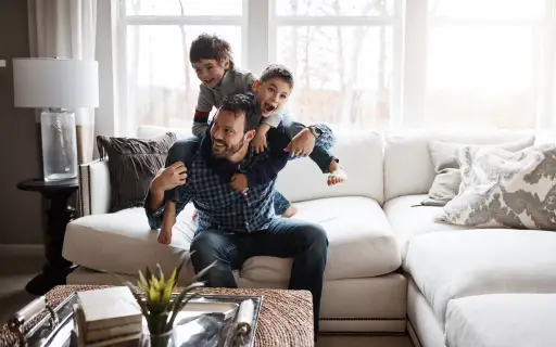 父亲和两个儿子在客厅玩耍