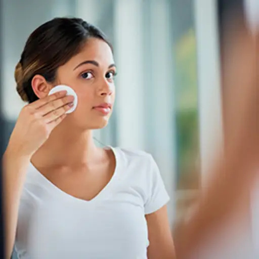 一个女人用化妆棉擦脸。