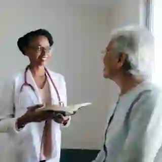 young doctor talking to senior female patient