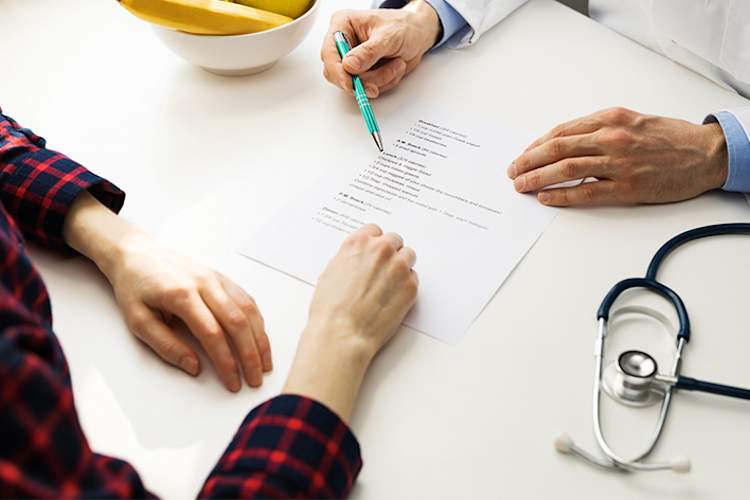 医生与妇女讨论良好的营养,健康的饮食计划。