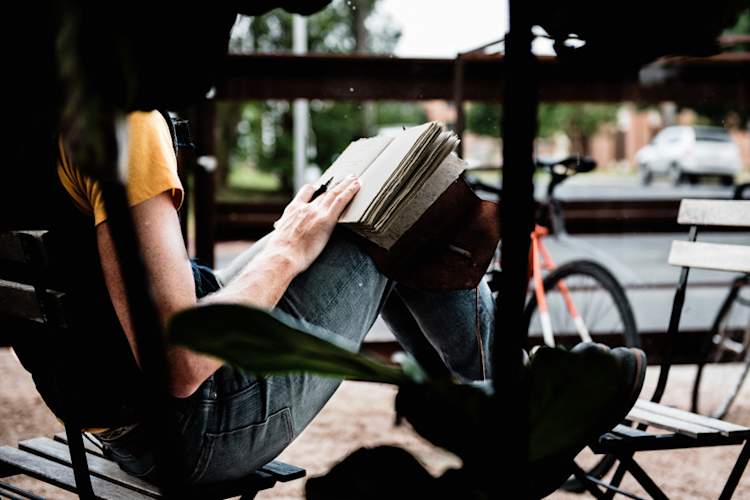 人坐在外面杂志写作
