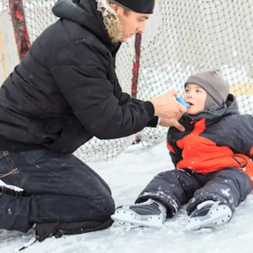 孩子在和家人打冰球时使用吸入器。