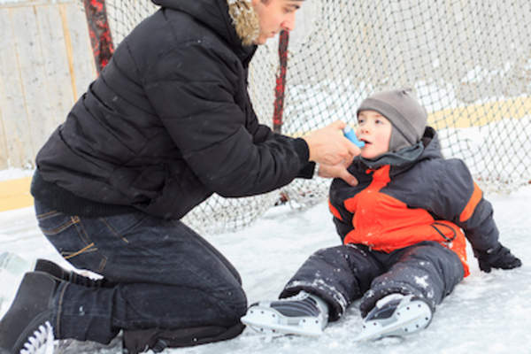 使用吸入器的孩子,而打曲棍球与家人。