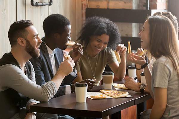 在比萨店微笑一群朋友。