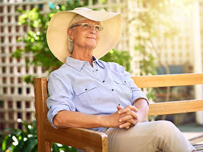 戴宽边帽在外面放松的老太太。