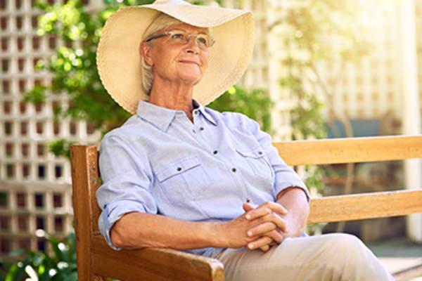 戴宽边帽在外面放松的老太太。