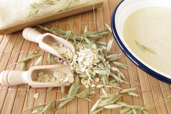 燕麦浴的概念,木材舀燕麦新鲜谷物与洗手盆。