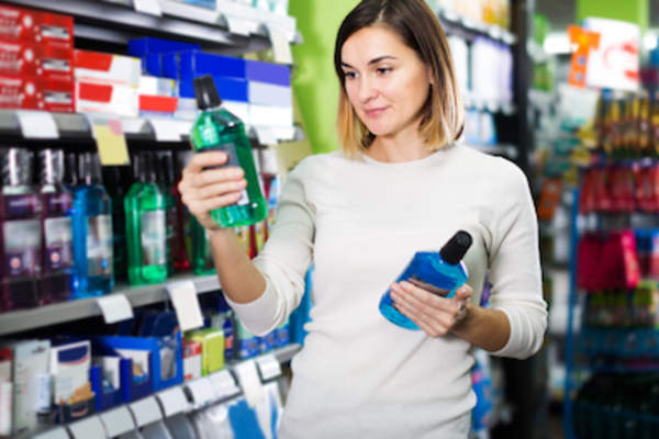 女子在超市比较漱口水。