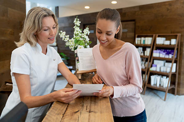 一位女士正在和水疗中心的接待员谈话。