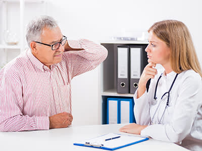 颈部疼痛的病人与医生交谈。