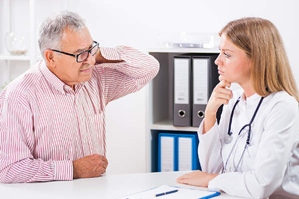 颈部疼痛的病人与医生交谈。