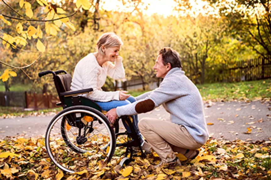 轮椅的妇女有她的丈夫的秋天。