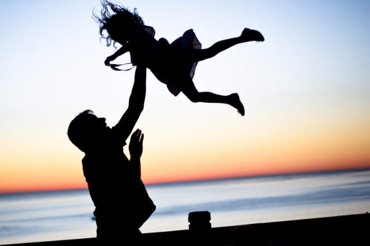 silhouette of father playing with daughter