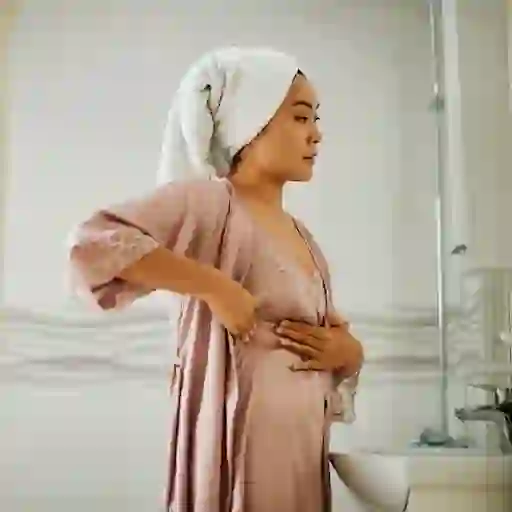 一位妇女在家里检查自己的乳房