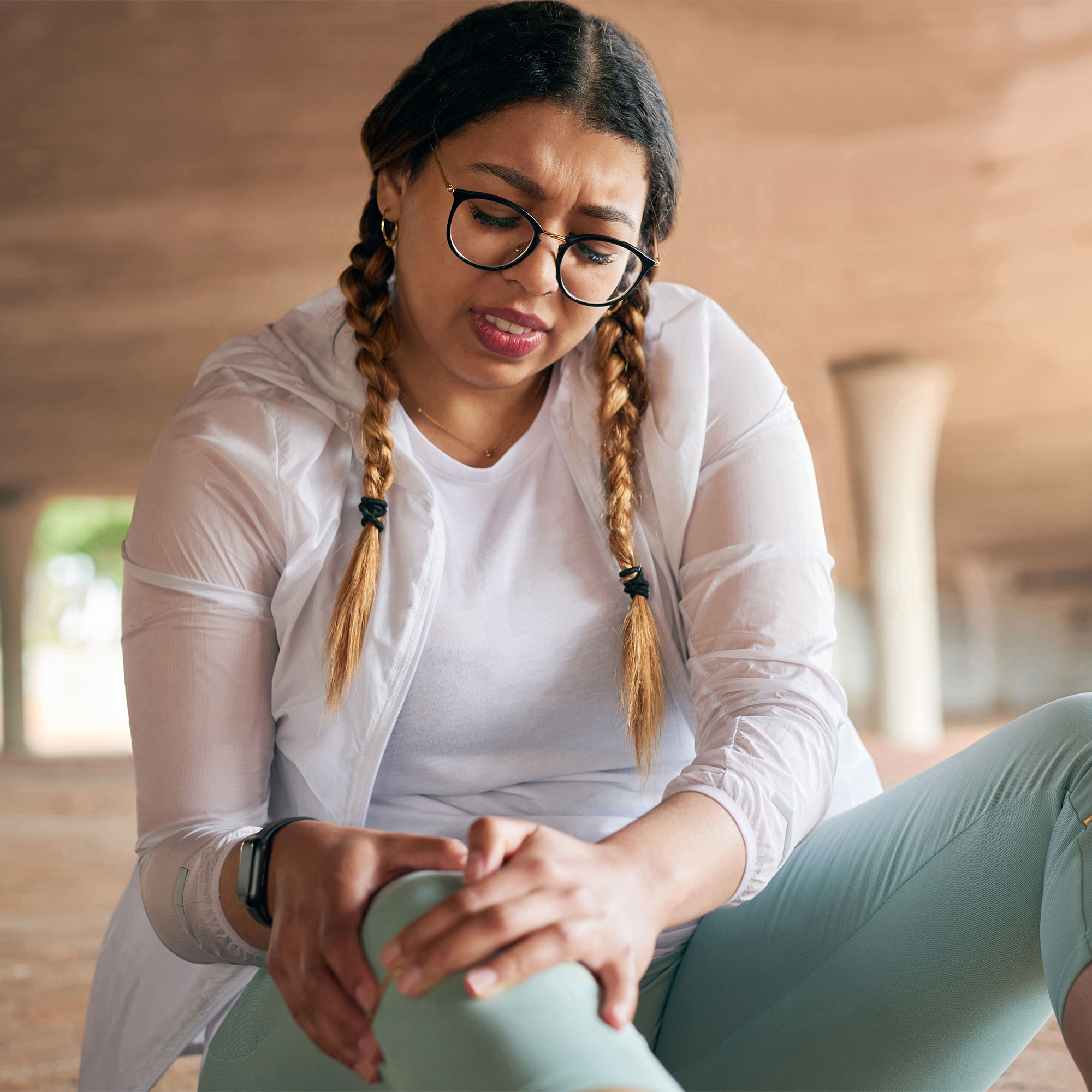 女人痛苦地握住膝盖
