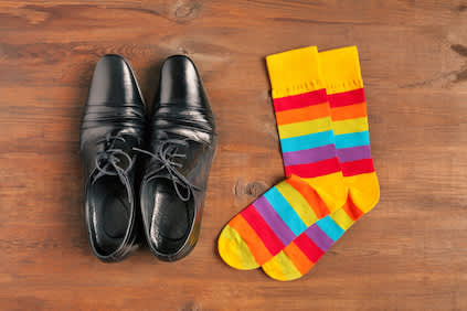 木地板上的黑色礼服鞋和彩色袜子。