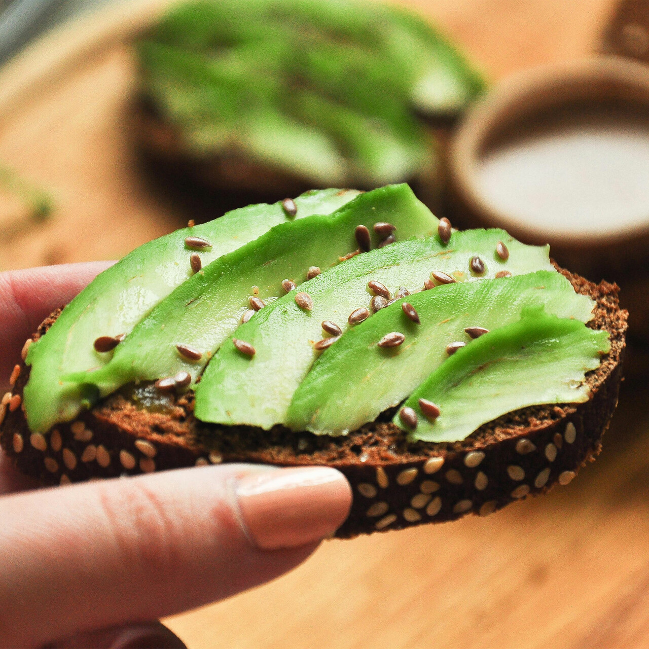 特写人持有鳄梨面包种子撒在上面