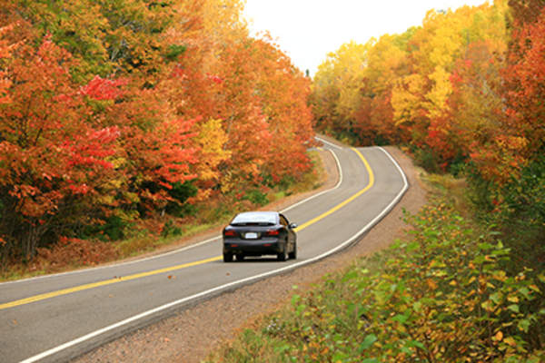 Car driving down a country road.