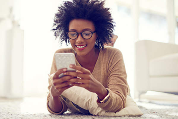 一位女士在用手机时面带微笑。