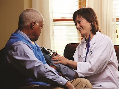 医生在病人家中为病人量血压。