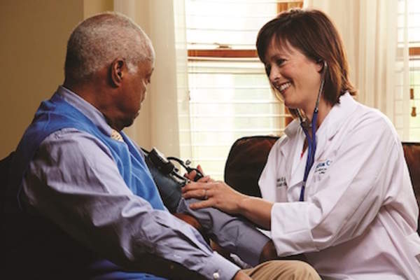 医生在病人家中为病人量血压。