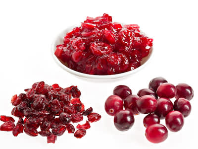罐装整个蔓越莓在碗里，与干和新鲜蔓越莓在碗的前面。
