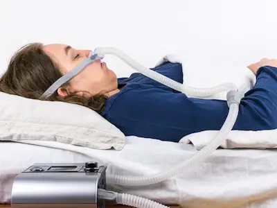 一名妇女用CPAP机治疗睡眠呼吸暂停。