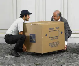 两个人抬着一个大箱子，累得直不起腰来。