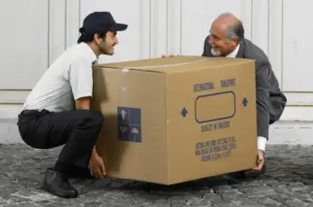两个人抬着一个大箱子，累得直不起腰来。
