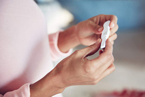 Woman holding a pregnancy test.