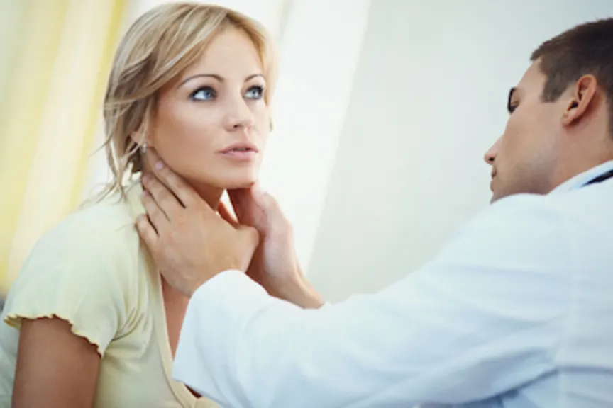 Doctor examining patients thyroid.