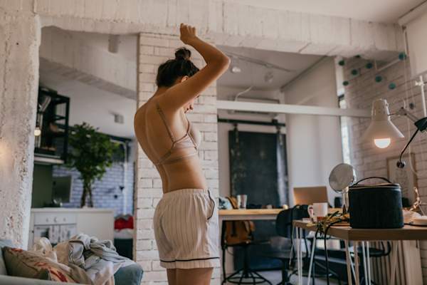 女人在卧室做自我乳房检查