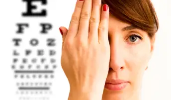 一名妇女用手捂着眼睛，在眼科医生。