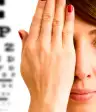 一位妇女用手捂住眼睛看眼科医生。