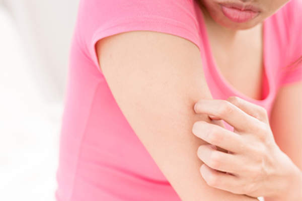 在粉红色的衬衫的女子抓她的手臂。