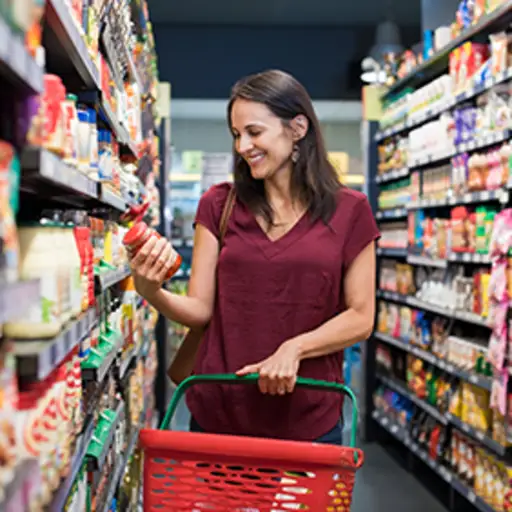 Woman in a supermarket reading a food label.